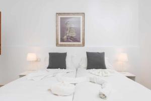 a bedroom with two white beds and a picture on the wall at Green Maca, adosado centro Campanet in Campanet