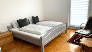 a white bed in a room with a wooden floor at Sunny Freudenstadt in Freudenstadt