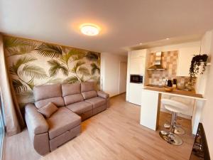 a living room with a couch and a kitchen at La Perla in Playa de las Americas