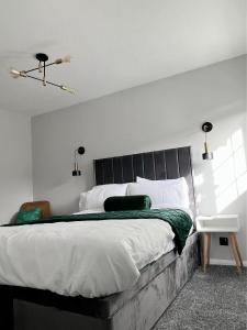 a bedroom with a large bed with a black headboard at Stunning Newly Decorated Flat with Private Entrance in London