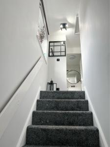 a staircase in a home with white walls at Stunning Newly Decorated Flat with Private Entrance in London