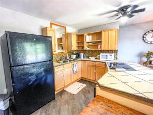 a kitchen with a black refrigerator and wooden cabinets at The Loft inside The Roost in Jordan