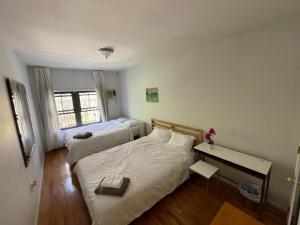 a bedroom with two beds and a desk and a window at Spacious Bedroom for 4 in shared Townhouse+garden in Brooklyn