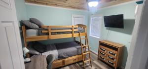 1 Schlafzimmer mit 2 Etagenbetten und einem Flachbild-TV in der Unterkunft The Guest House in Largo