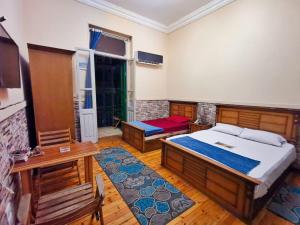 a bedroom with a bed and a desk and a table at Cairo Lodge Hostel in Cairo