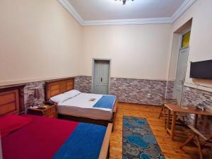 a bedroom with two beds and a table and a television at Cairo Lodge Hostel in Cairo