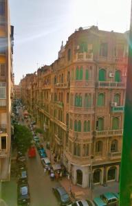 a large building with cars parked next to a street at Cairo Lodge Hostel in Cairo