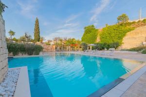 a large swimming pool with blue water at Cava Li Santi Residence in Santa Caterina di Nardò