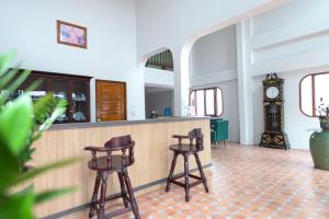 un bar con dos taburetes y un reloj de abuelo en ChomTique Hotel en Ban Chamun (2)