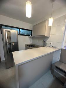 uma cozinha com um balcão branco e um frigorífico em Vila Atlantida em Luís Correia