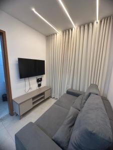 uma sala de estar com um sofá e uma televisão de ecrã plano em Vila Atlantida em Luís Correia