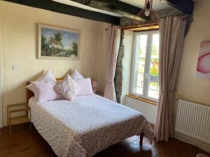 1 dormitorio con cama y ventana en La Vieille Boulangerie, en Langourla