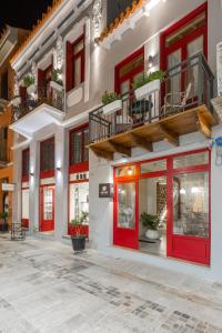 una fachada de un edificio con puertas y ventanas rojas en Danae Hotel en Nafplio