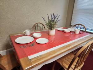 a table with a red table cloth and plates on it at Urban Getaway on 7th in Niagara Falls