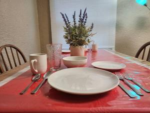 una mesa con platos y utensilios sobre un mantel rojo en Urban Getaway on 7th, en Niagara Falls