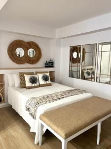 um quarto com uma cama grande e 2 espelhos em EL PISITO SAND, a 700 metros del casco antiguo em Marbella