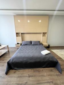 a bedroom with a large bed with a black comforter at BUREAU RESİDENCE STÜDYO DAİRE in Kartepe