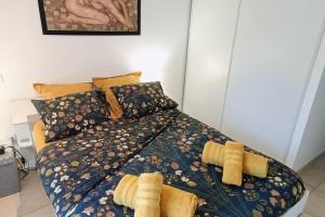 um quarto com uma cama com edredão amarelo e almofadas em Bel appartement de standing à Boulouris em Saint-Raphaël