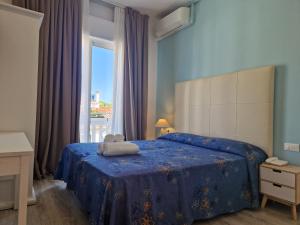 a bedroom with a bed with a teddy bear on it at Hotel Danubio in Lido di Jesolo