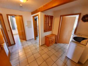 a kitchen with a white refrigerator and a tile floor at Ferienwohnung Matschak OG links in Fehmarn +9 photos