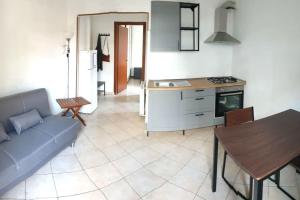 a kitchen and a living room with a couch and a table at Casa Aurelia in Rome