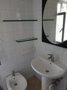 a white bathroom with a sink and a mirror at Casa Aurelia in Rome