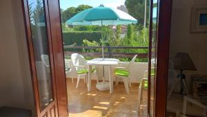 een patio met een tafel en stoelen en een parasol bij Apartment with private balcony in San Javier