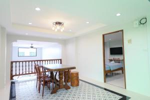 a dining room with a table and chairs and a mirror at ChomTique Hotel in Ban Chamun (2)