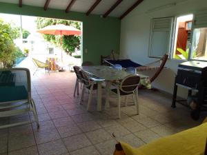 a dining room with a table and chairs and an umbrella at Sunbeachparadise in Port-Louis