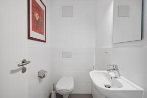 a white bathroom with a sink and a toilet at EXQUIS Design 2BR Apartment BAUHAUS I Balkon I Parkplatz I Top-Lage I Mercedes-Benz I Kinderbetten in Böblingen +6 photos