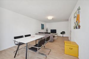 a living room with a table and chairs and a couch at EXQUIS Design 2BR Apartment BAUHAUS I Balkon I Parkplatz I Top-Lage I Mercedes-Benz I Kinderbetten in Böblingen