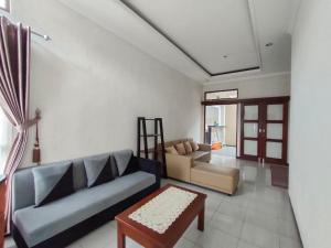 - un salon avec un canapé et une table dans l'établissement Omah Tawang Homestay Temanggung, à Temanggung