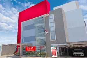 a red building with a car parked in front of it at Red Orchid Hotel by Sajiwa in Semarang
