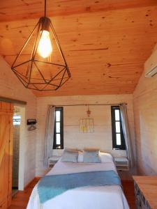 um quarto com uma cama num chalé de madeira em Ocean Paradise 2 em Punta Del Diablo