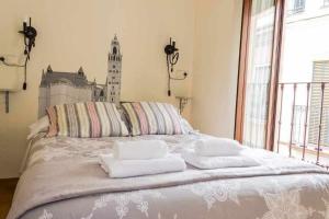 sypialnia z łóżkiem i dwoma ręcznikami na nim w obiekcie Casa con piscina junto catedral de sevilla w Sewilli +30 zdjęć