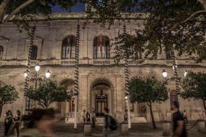 un edificio con gente caminando delante de él en Casa con piscina junto catedral de sevilla, en Sevilla