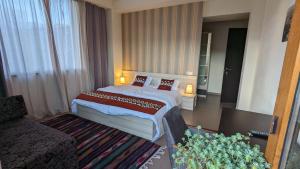 Habitación de hotel con cama y sofá en Melia Hotel en Gudauri