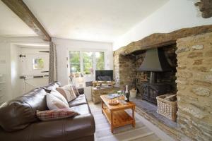 un soggiorno con divano in pelle e camino di Idyllic Cottage in Dorset Garden & Parking a Gillingham