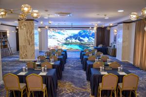 a conference room with tables and chairs and a large window at Garden Hotel & SPA in Bishkek