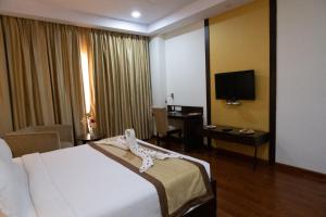 a hotel room with a bed and a television at Hyphen Premier-Business Hotel in Meerut