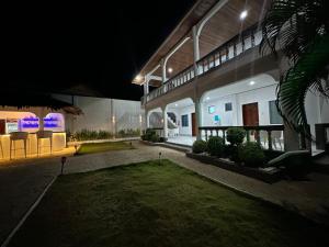 a night view of a building with a yard at Pawikan Boutique Hotel in Moalboal