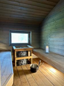 a room in a wooden cabin with a bowl and a window at Kuusiston majatalo 