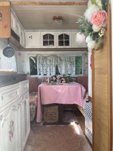 Tiny House Bohême pour amoureux en Day use 12 à 20H في Pont-à-Celles: مطبخ مع حوض وطاولة في rv