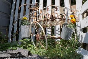 a garden with two metal buckets with flowers in them at Tiny House Bohême pour amoureux en Day use 12 à 20H in Pont-à-Celles