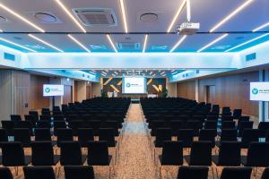 una sala de conferencias con sillas y una pantalla en el centro en V Spa & Conference Hotel en Tartu