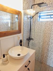 a bathroom with a white sink and a shower at Ocean Paradise 2 in Punta Del Diablo