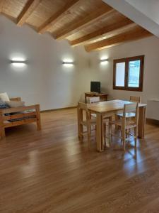 sala de estar con mesa de madera y sillas en Cal Vallverdú 2D, en Preixana
