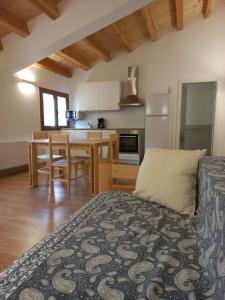 eine Küche und ein Esszimmer mit einem Bett in einem Zimmer in der Unterkunft Cal Vallverdú 2D in Preixana
