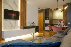 a living room with a couch and a kitchen at Supernova Royal Residence in Novi Sad