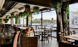 a restaurant with tables and chairs and a view of the water at Marina Magic Getaways - Your Waterfront Retreat in Patterson Lakes